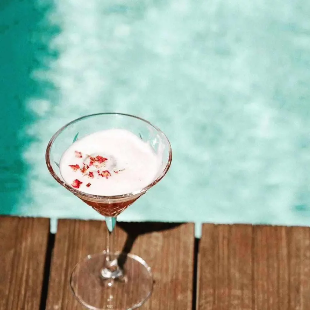 Cocktail dans un verre à martini au bord d'une piscine